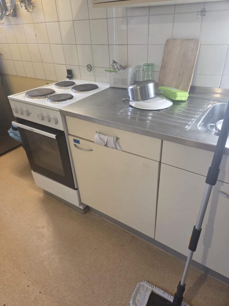 Gemeinschaftsküche während der Unterhaltsreinigung mit Flachmopp